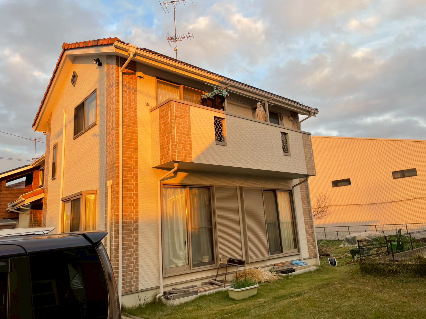 庭からみた白と石目調の外壁の建物